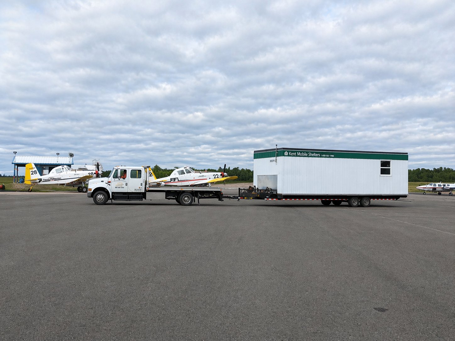 Freddy Tow Co. tow truck moving a mobile office trailer at YFC, Fredericton International Airport.